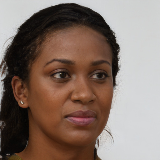 Joyful black young-adult female with long  brown hair and brown eyes