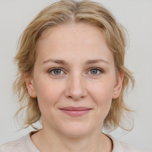 Joyful white young-adult female with medium  brown hair and blue eyes