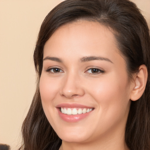 Joyful white young-adult female with long  brown hair and brown eyes