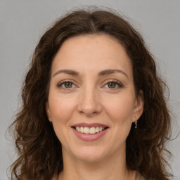 Joyful white adult female with long  brown hair and green eyes