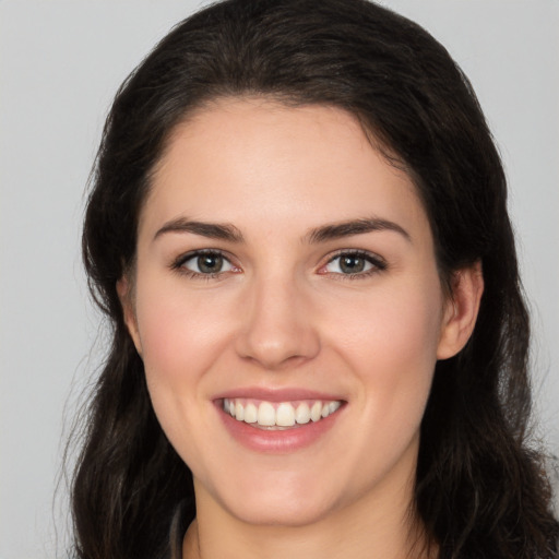 Joyful white young-adult female with long  brown hair and brown eyes