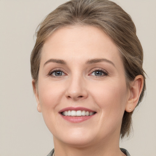 Joyful white young-adult female with medium  brown hair and grey eyes