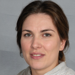 Joyful white adult female with medium  brown hair and brown eyes