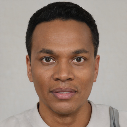 Joyful black young-adult male with short  black hair and brown eyes