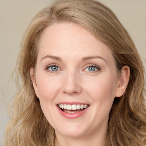 Joyful white young-adult female with long  brown hair and blue eyes