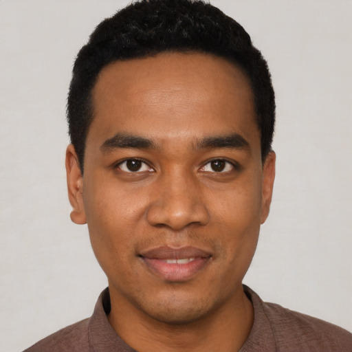 Joyful black young-adult male with short  black hair and brown eyes