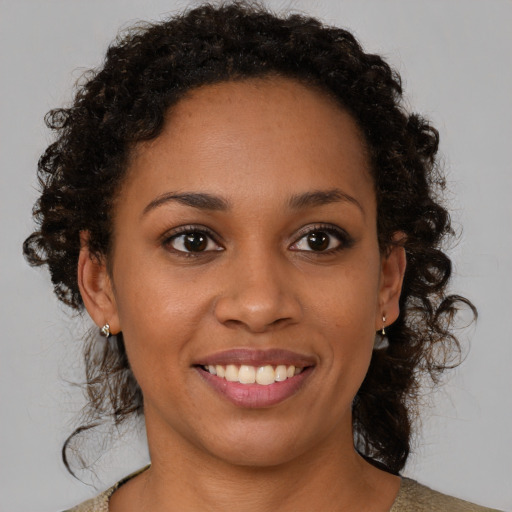 Joyful black young-adult female with medium  brown hair and brown eyes