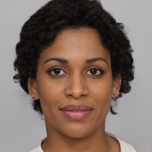 Joyful black young-adult female with short  brown hair and brown eyes