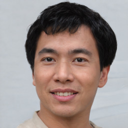 Joyful asian young-adult male with short  black hair and brown eyes