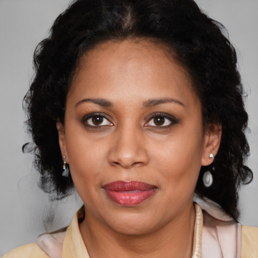 Joyful latino adult female with medium  brown hair and brown eyes