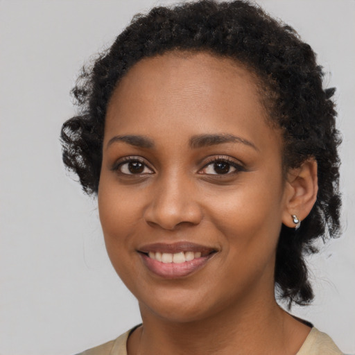 Joyful black young-adult female with long  brown hair and brown eyes