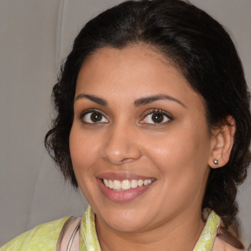 Joyful latino young-adult female with medium  brown hair and brown eyes