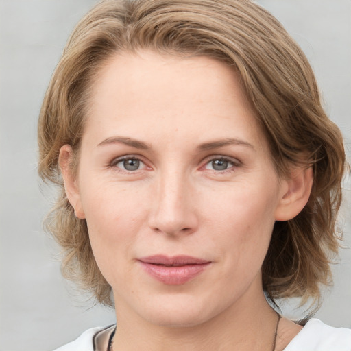 Joyful white young-adult female with medium  brown hair and blue eyes