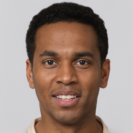 Joyful black young-adult male with short  black hair and brown eyes