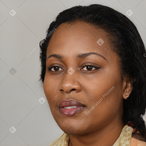Joyful black young-adult female with long  black hair and brown eyes