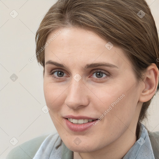 Joyful white young-adult female with medium  brown hair and grey eyes