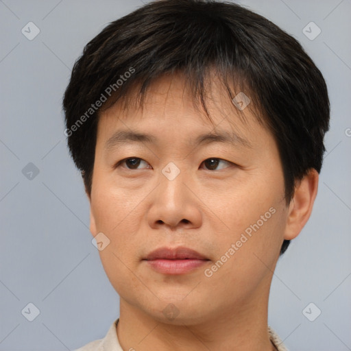 Joyful asian adult male with short  brown hair and brown eyes