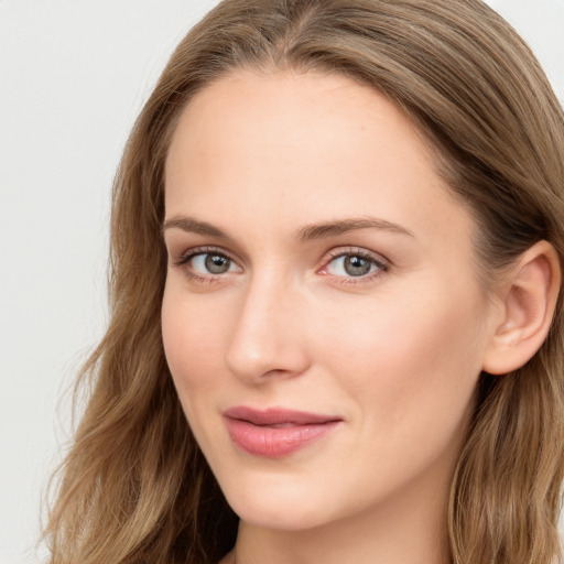 Joyful white young-adult female with long  brown hair and blue eyes