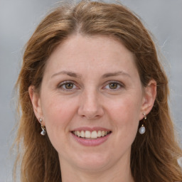 Joyful white adult female with long  brown hair and grey eyes