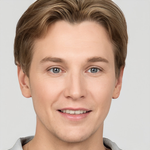 Joyful white young-adult male with short  brown hair and grey eyes