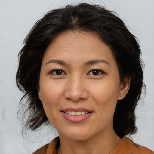 Joyful asian adult female with medium  brown hair and brown eyes
