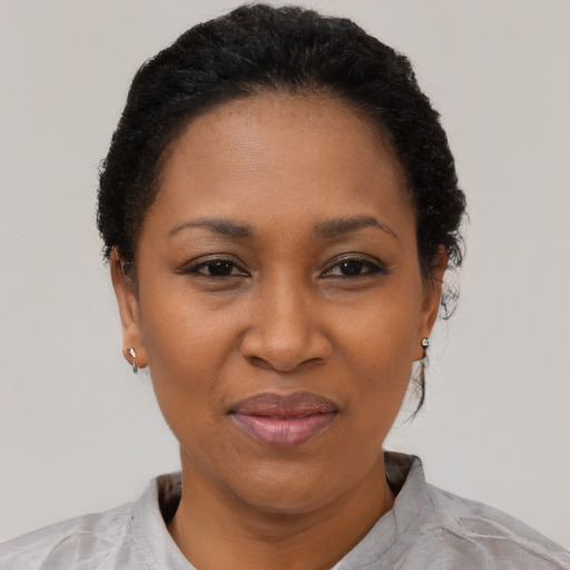 Joyful black adult female with short  black hair and brown eyes