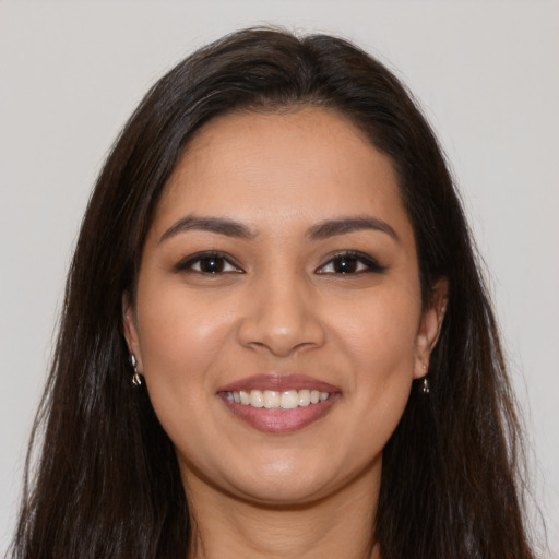 Joyful latino young-adult female with long  brown hair and brown eyes