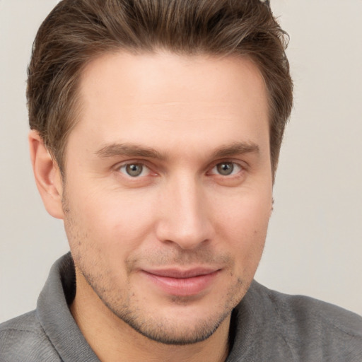 Joyful white young-adult male with short  brown hair and grey eyes