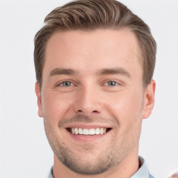 Joyful white young-adult male with short  brown hair and grey eyes