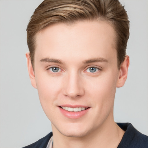 Joyful white young-adult male with short  brown hair and grey eyes