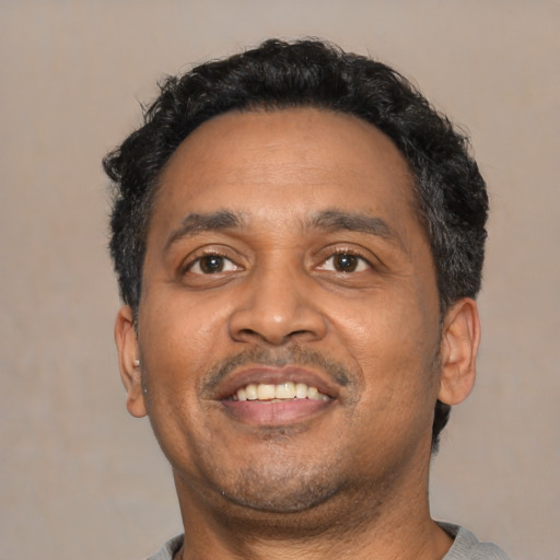 Joyful latino adult male with short  black hair and brown eyes