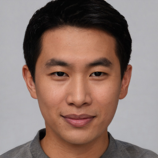 Joyful asian young-adult male with short  brown hair and brown eyes