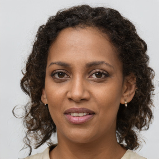Joyful black young-adult female with medium  brown hair and brown eyes