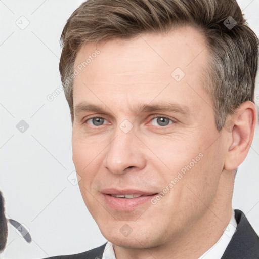 Joyful white adult male with short  brown hair and grey eyes