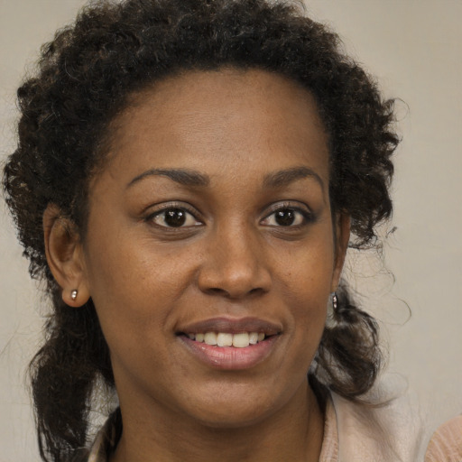 Joyful black young-adult female with medium  brown hair and brown eyes