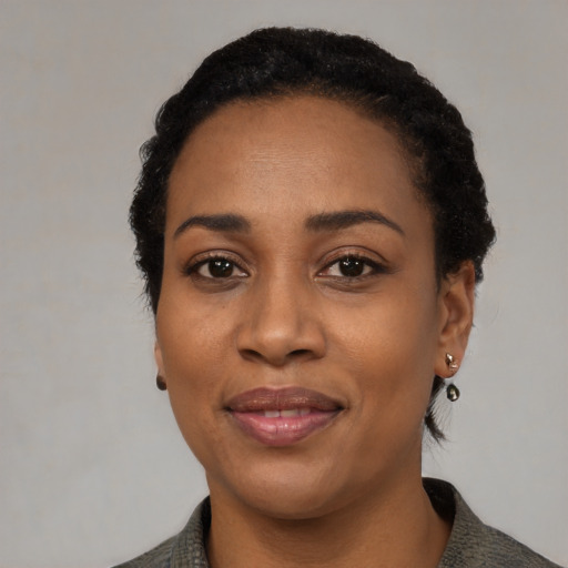 Joyful black adult female with short  black hair and brown eyes