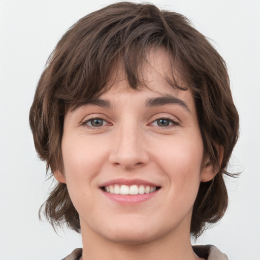 Joyful white young-adult female with medium  brown hair and green eyes