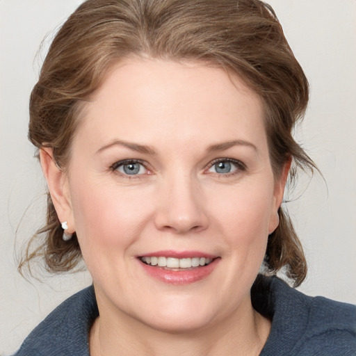 Joyful white young-adult female with medium  brown hair and blue eyes