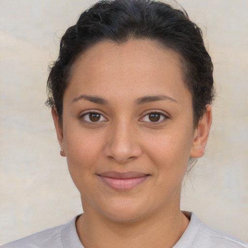Joyful latino young-adult female with short  brown hair and brown eyes