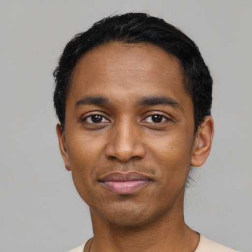 Joyful black young-adult male with short  black hair and brown eyes