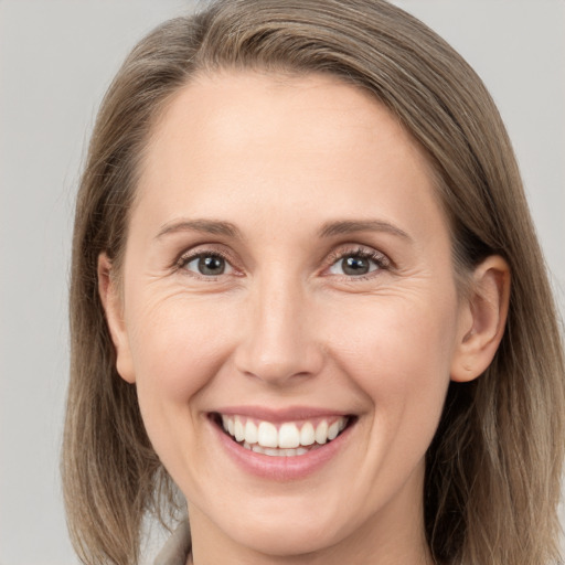 Joyful white adult female with medium  brown hair and grey eyes