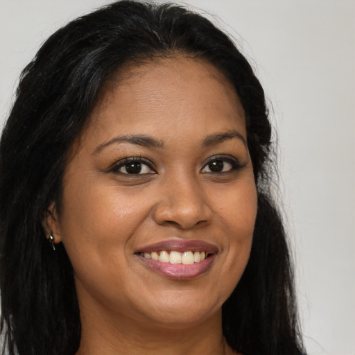Joyful black young-adult female with long  brown hair and brown eyes
