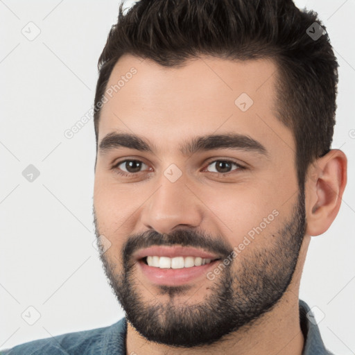 Joyful white young-adult male with short  black hair and brown eyes