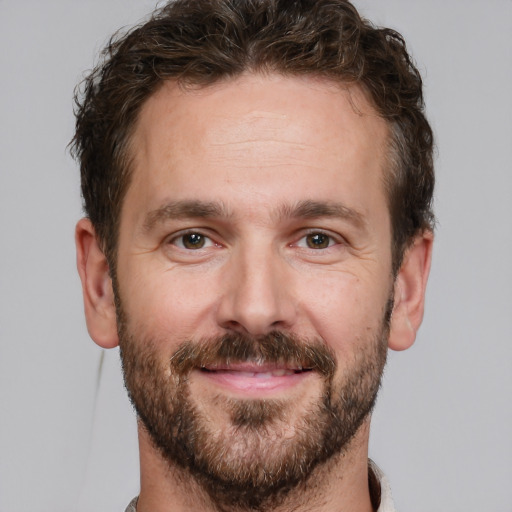 Joyful white adult male with short  brown hair and grey eyes