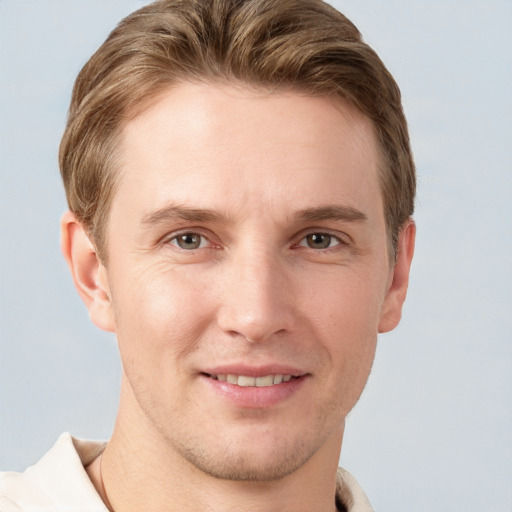 Joyful white young-adult male with short  brown hair and grey eyes