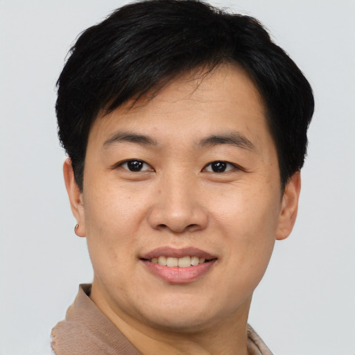 Joyful asian young-adult male with short  brown hair and brown eyes