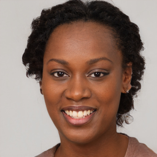 Joyful black young-adult female with long  brown hair and brown eyes