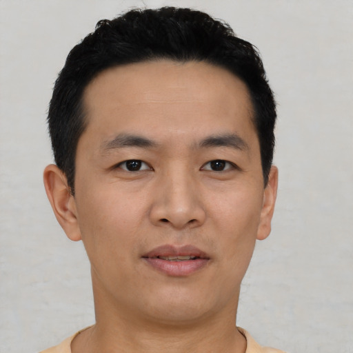 Joyful asian young-adult male with short  black hair and brown eyes