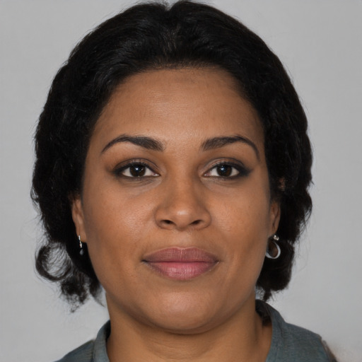 Joyful black adult female with medium  brown hair and brown eyes