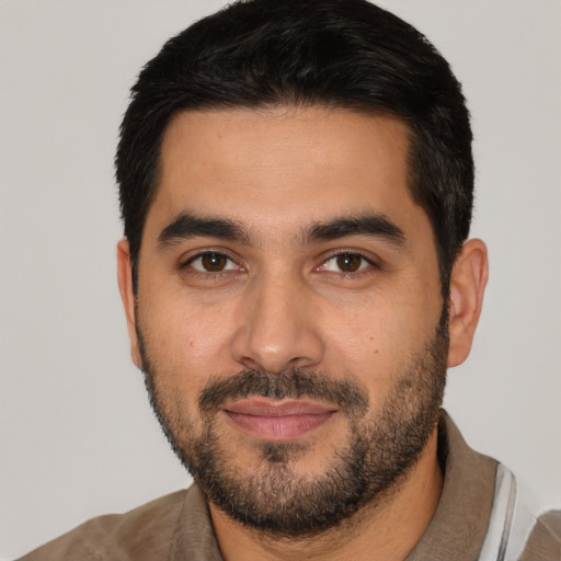 Joyful latino young-adult male with short  black hair and brown eyes